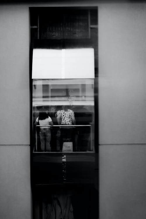 电梯里的人的灰度摄影 · 免费素材图片