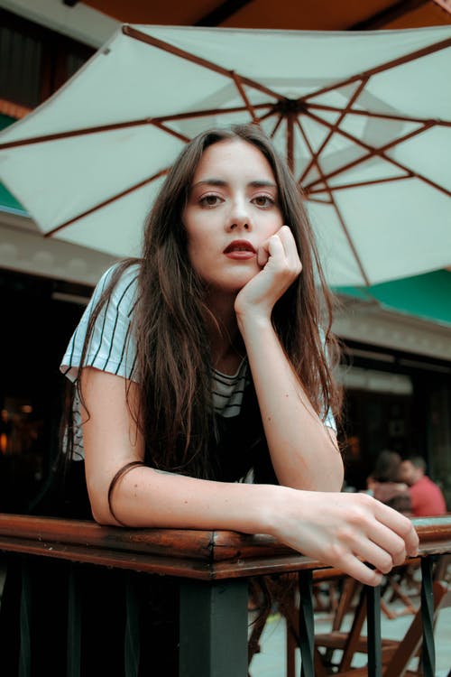 女人靠在棕色的栅栏 · 免费素材图片