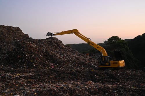 在垃圾填埋场工作的挖掘机 · 免费素材图片