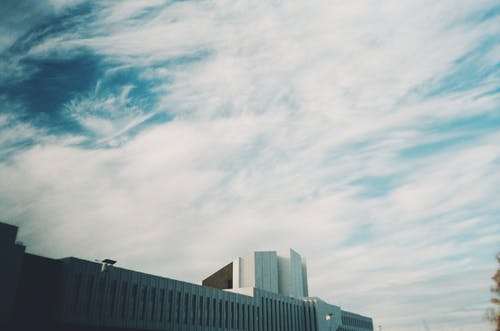 白云下的灰色混凝土建筑 · 免费素材图片