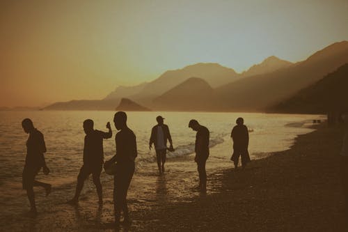 一群人站在海岸线上 · 免费素材图片