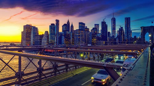 高角度拍摄的车辆在一座桥上，以黄昏的城市景观 · 免费素材图片