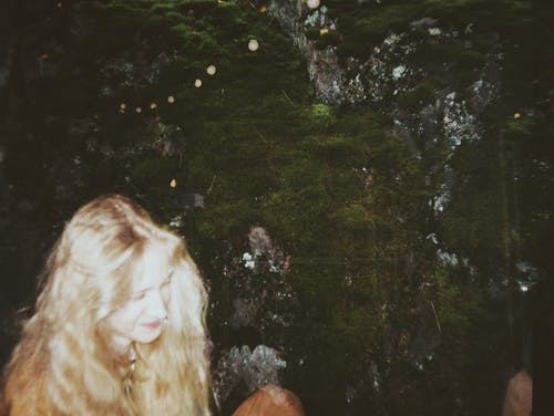 站在绿色绘画旁边的女人 · 免费素材图片