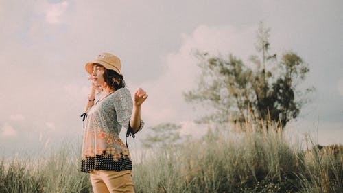 站立的妇女戴棕色帽子的选择聚焦摄影 · 免费素材图片