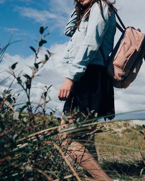 女人穿着植物附近的背包 · 免费素材图片