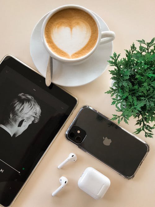 黑色iphone 11在airpods和咖啡杯旁边 · 免费素材图片