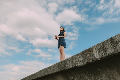 女人站在桥上的低角度照片 · 免费素材图片