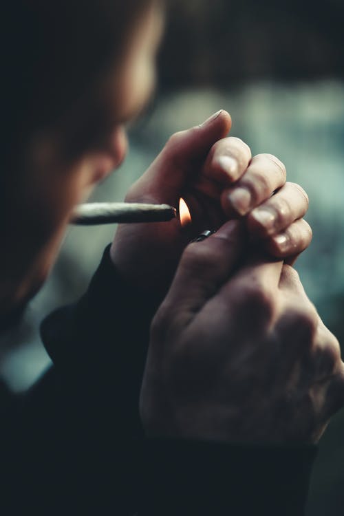 男子照明香烟的选择性聚焦摄影 · 免费素材图片
