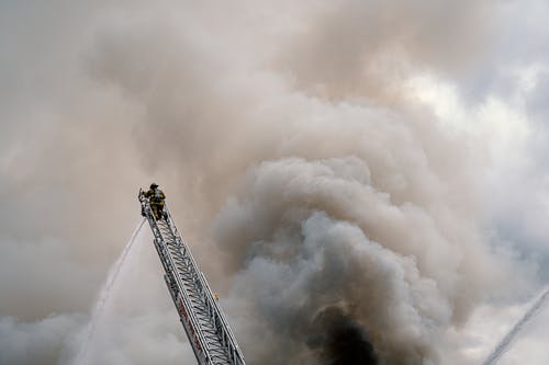 梯子顶部的消防员 · 免费素材图片