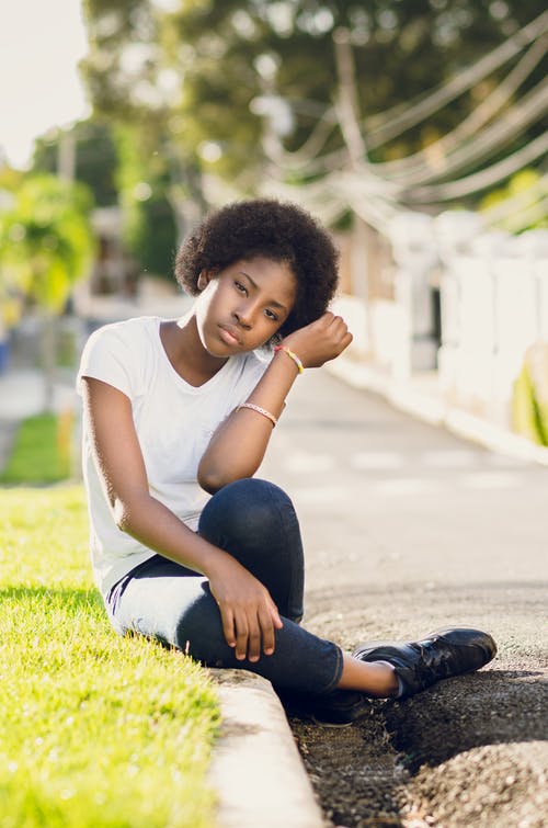 坐在草地上的白色t恤的女人 · 免费素材图片