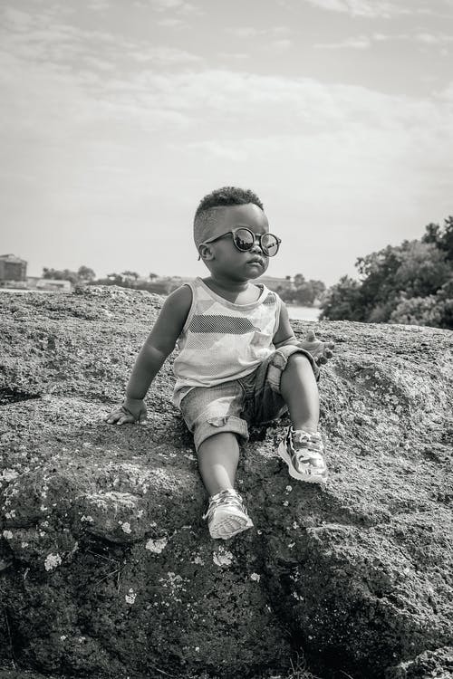 男孩坐在岩石上 · 免费素材图片