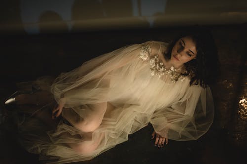 女人穿着白色的裙子，坐在地板上 · 免费素材图片