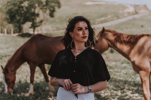 女人站在匹棕色的马附近 · 免费素材图片