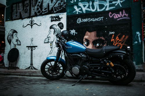 摩托车停在墙上涂鸦的照片 · 免费素材图片