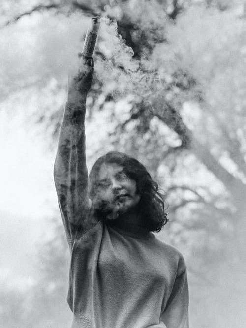 女人抱着烟弹 · 免费素材图片