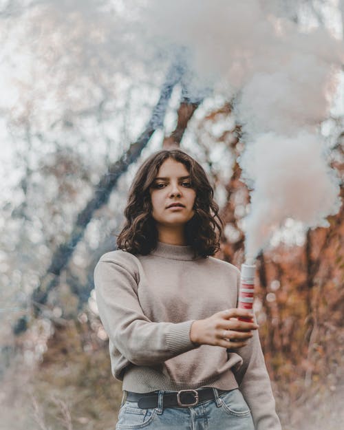 女人抱着烟弹 · 免费素材图片