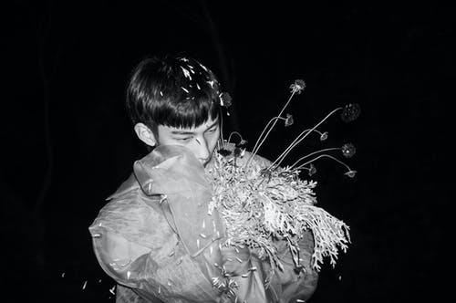 该名男子手持鲜花的单色照片 · 免费素材图片