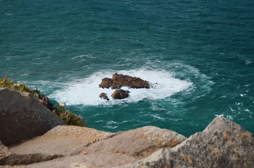 白天海上岩石形成的照片 · 免费素材图片