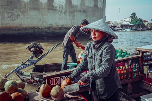 女人穿着灰色夹克骑独木舟船 · 免费素材图片
