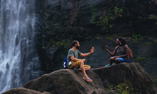 男人和女人在瀑布附近聊天 · 免费素材图片