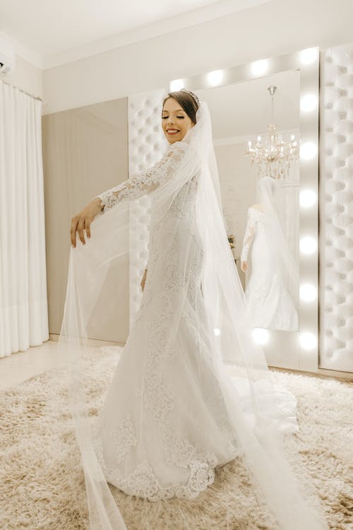 站在虚荣镜前的白色婚纱的女人 · 免费素材图片