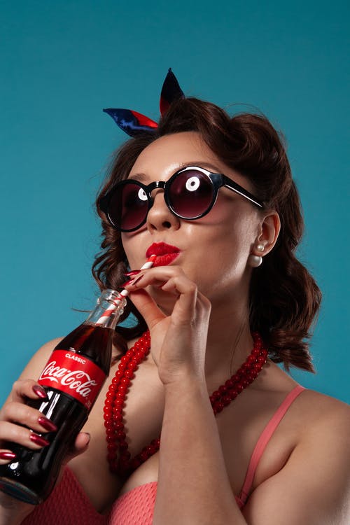 女人拿着可口可乐玻璃瓶 · 免费素材图片