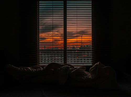 日落时在黑暗的房间里弄皱的毯子 · 免费素材图片