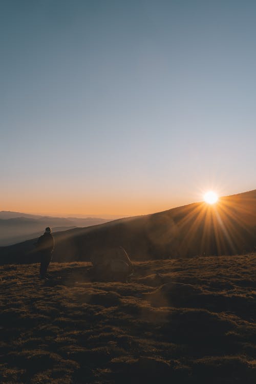 无法识别的徒步旅行者在山谷欣赏日落 · 免费素材图片