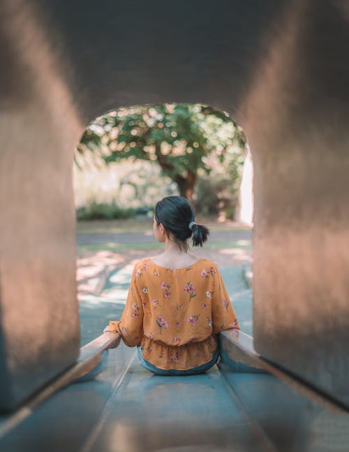 橙色礼服的妇女坐在棕色木船坞 · 免费素材图片