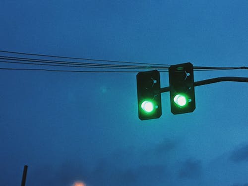 反对黑暗的天空的绿色交通灯 · 免费素材图片