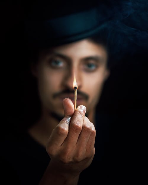 男人手上拿着燃烧的棍子 · 免费素材图片