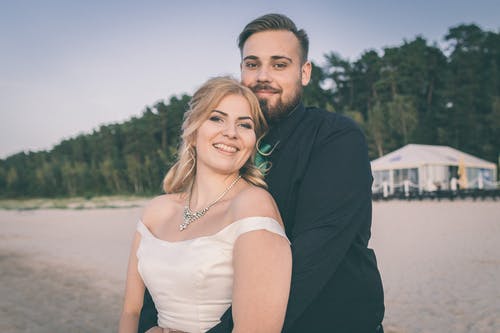 黑色西装外套的男人旁边穿着白色连衣裙的女人 · 免费素材图片