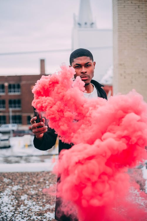 黑人与活跃的火炬与粉红色的烟雾 · 免费素材图片