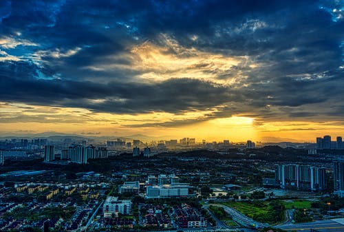 在日落期间多云的天空下的高层建筑的城市 · 免费素材图片