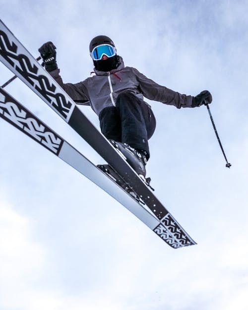 飞行的滑雪者在蔚蓝色的天空跳 · 免费素材图片