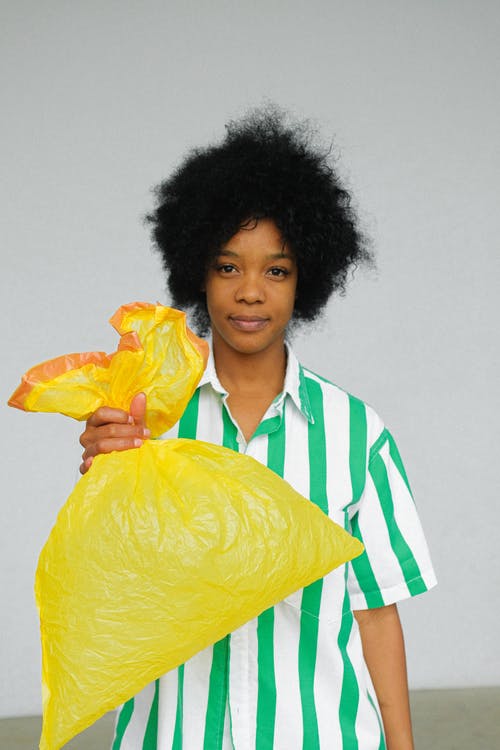 女人抱着黄色的塑料袋 · 免费素材图片