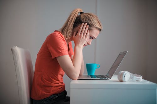 年轻人困扰的女人在家里使用笔记本电脑 · 免费素材图片