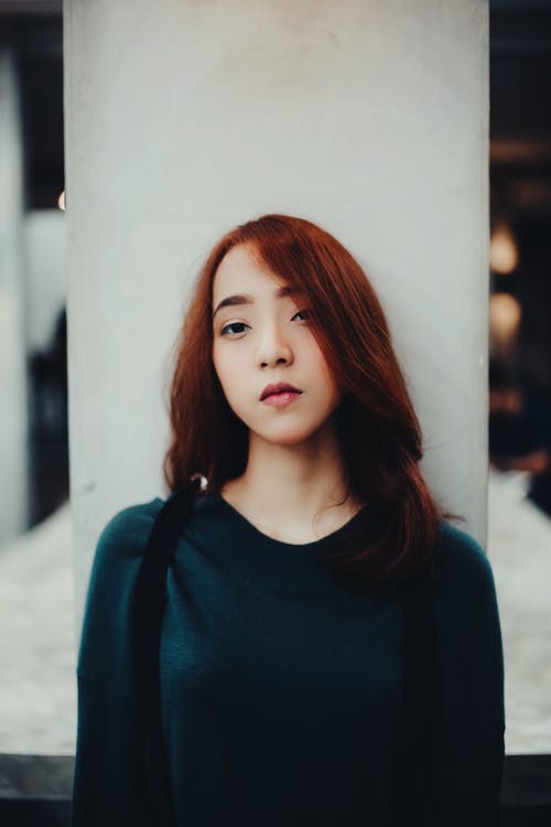 站立在专栏附近的年轻亚裔妇女 · 免费素材图片