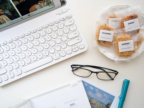 笔记本电脑和小吃附近眼镜在白色的表面 · 免费素材图片