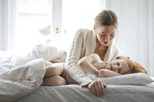 母亲和孩子在床上休息 · 免费素材图片