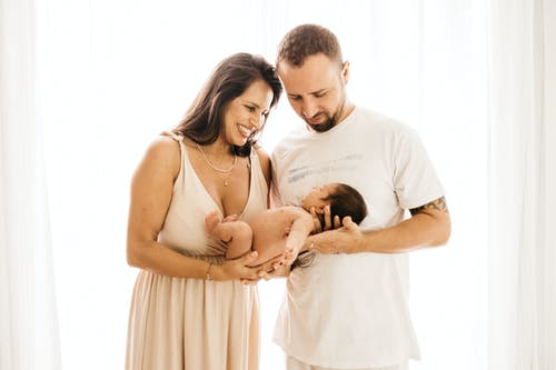 夫妇抱着婴儿的照片 · 免费素材图片