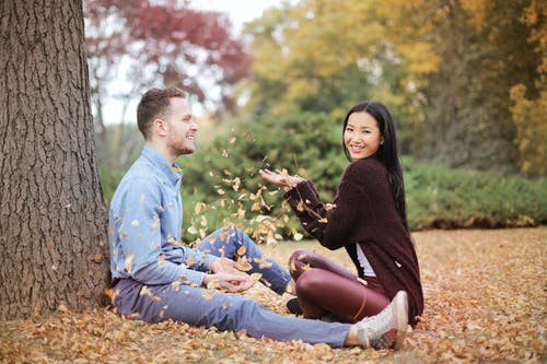 幸福的夫妻，分散在公园的叶子 · 免费素材图片