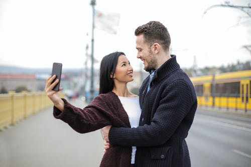 幸福的夫妻在自拍照时拥抱的选择性焦点照片 · 免费素材图片