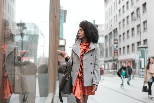 穿灰色外套的女人走商店橱窗的选择性聚焦照片 · 免费素材图片