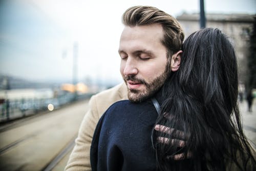 女人抱着男人的选择性焦点后视图照片 · 免费素材图片