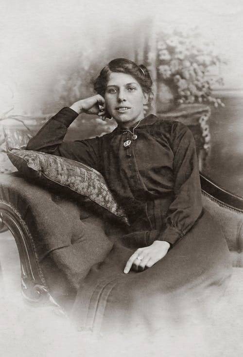 黑色按钮坐在沙发上的长袖衬衫的女人 · 免费素材图片