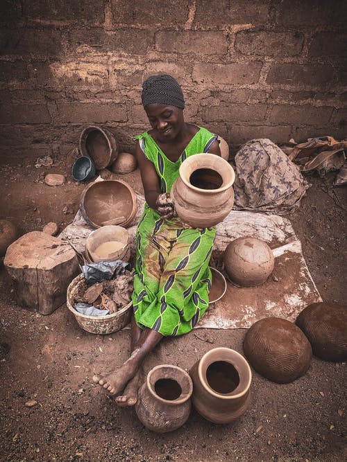 在村庄的街道上创建陶器的黑女人 · 免费素材图片