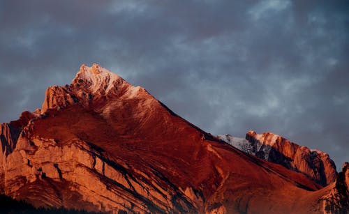 日落期间阴云密布的天空崎ough的山脊 · 免费素材图片