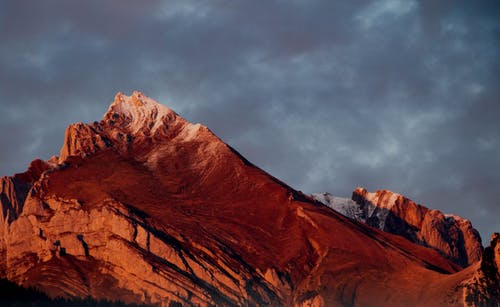 日落期间阴云密布的天空崎ough的山脊 · 免费素材图片