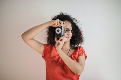 红顶女人用黑色相机拍照的肖像照片 · 免费素材图片